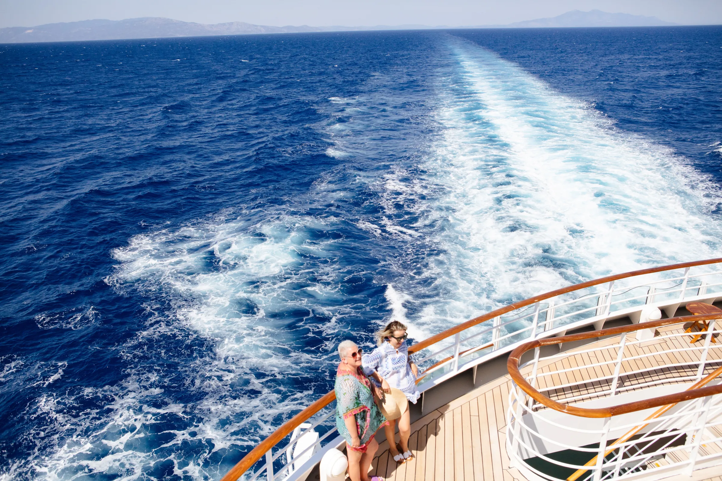 Guests at the stern of a Celestyal ship watching the wake