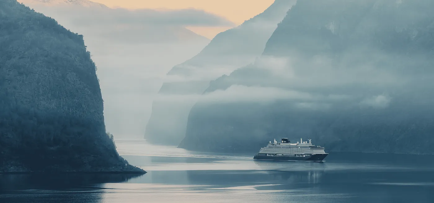 An Explora Journeys ship in a misty fjord
