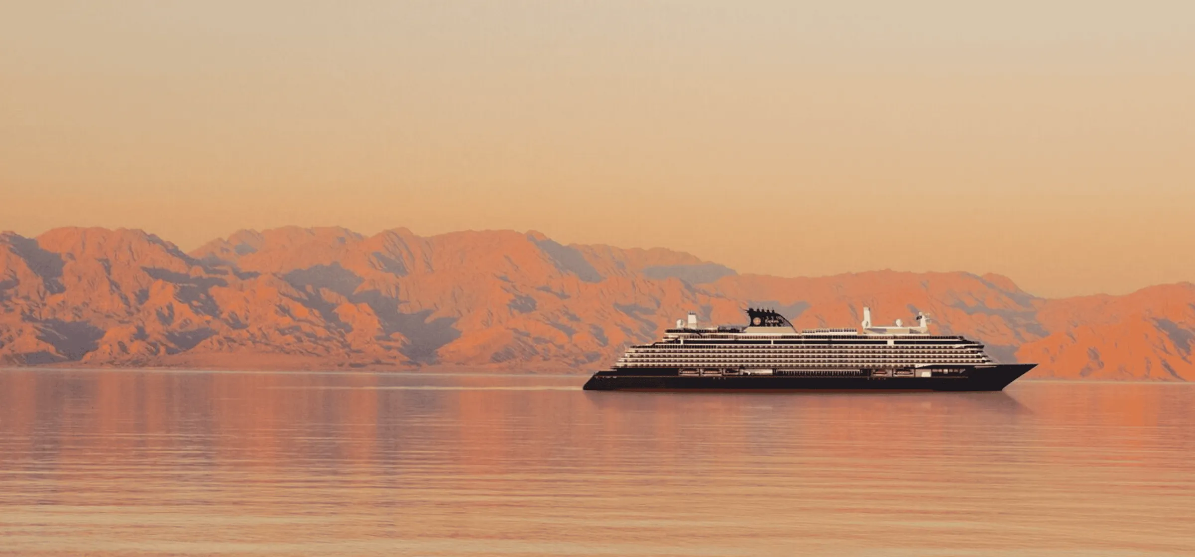 An Explora Journeys ship at sunset beneath mountains