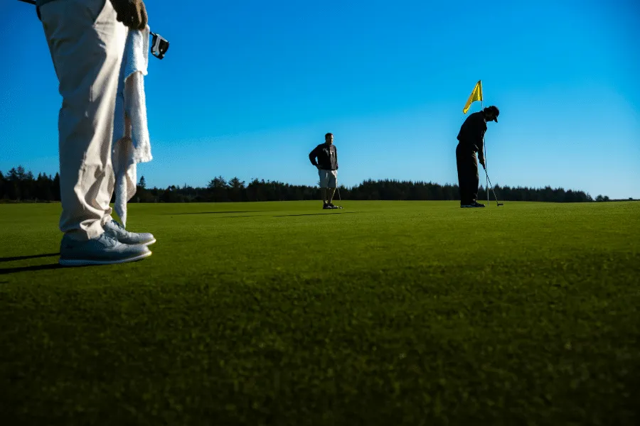 Golfers on a green by the sea