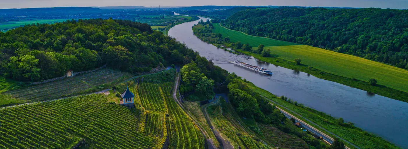 A river cruise ship on a European river at dusk